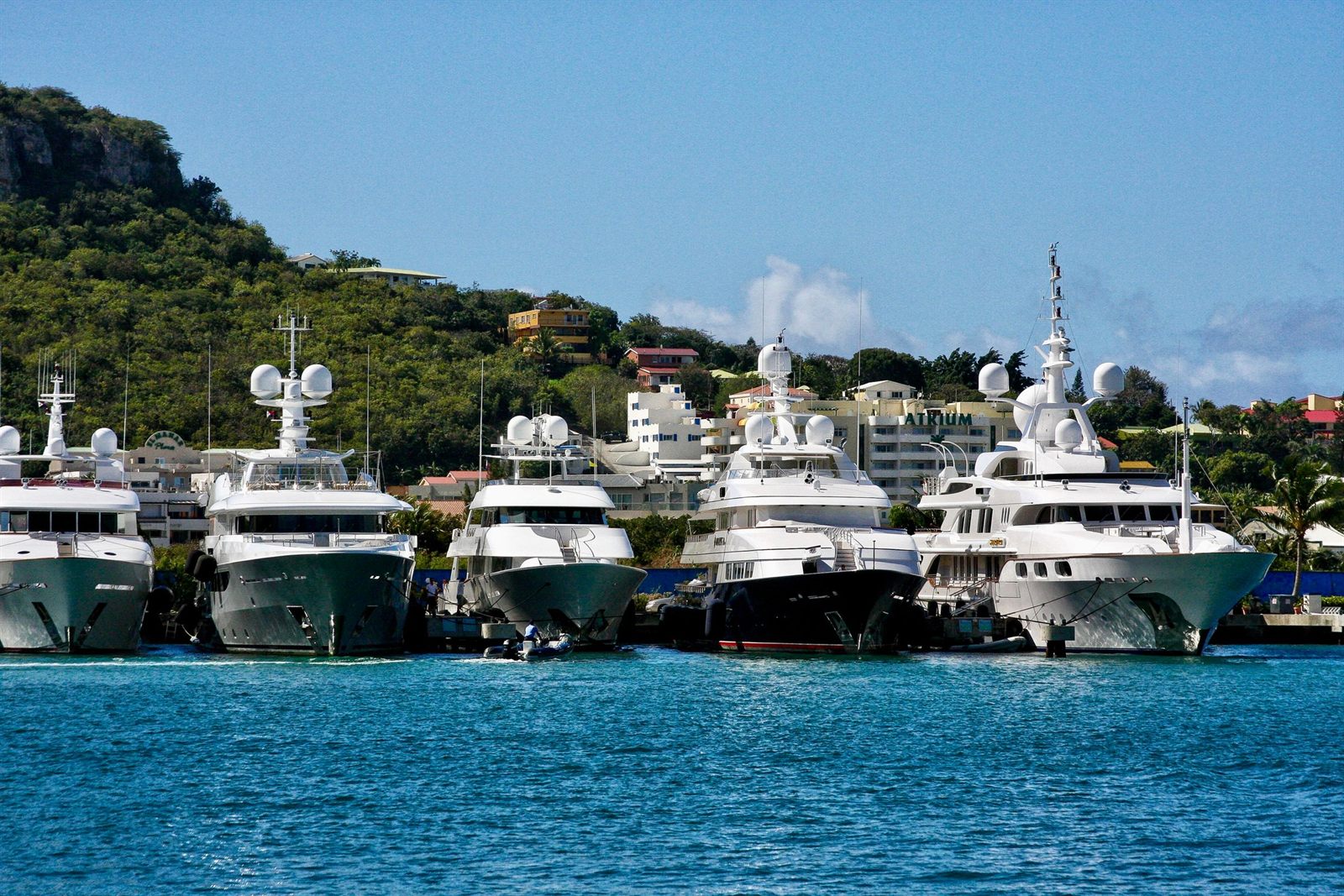 Row of white motor yachts moored in a sunny Caribbean marina